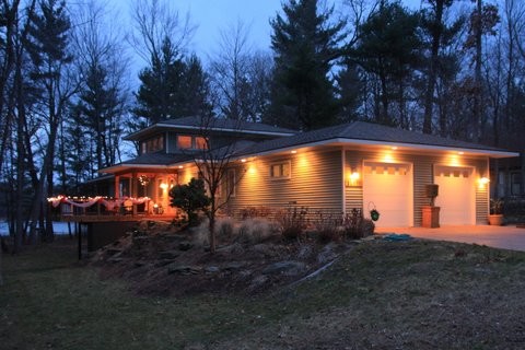 На фото: двухэтажный, зеленый дом среднего размера в современном стиле с облицовкой из винила и вальмовой крышей