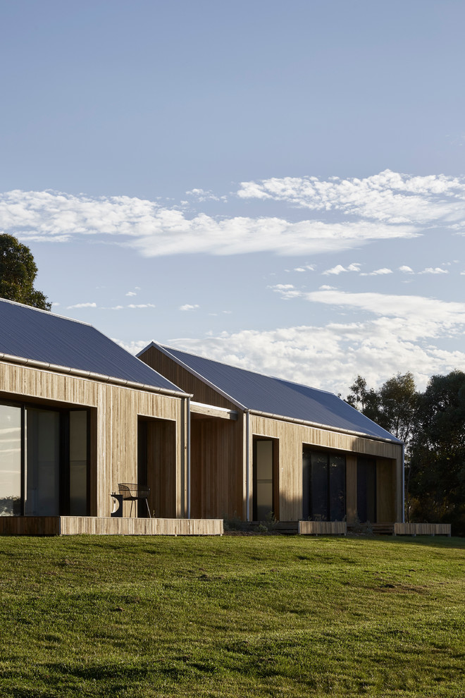 Diseño de fachada de casa marrón contemporánea grande de una planta con revestimiento de madera, tejado a dos aguas y tejado de metal