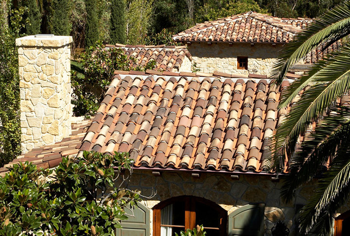 Réalisation d'une façade de maison beige méditerranéenne de taille moyenne et à un étage avec un revêtement mixte, un toit à quatre pans et un toit en tuile.