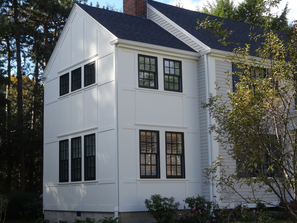 Imagen de fachada beige clásica renovada grande de dos plantas con revestimiento de aglomerado de cemento y tejado a dos aguas