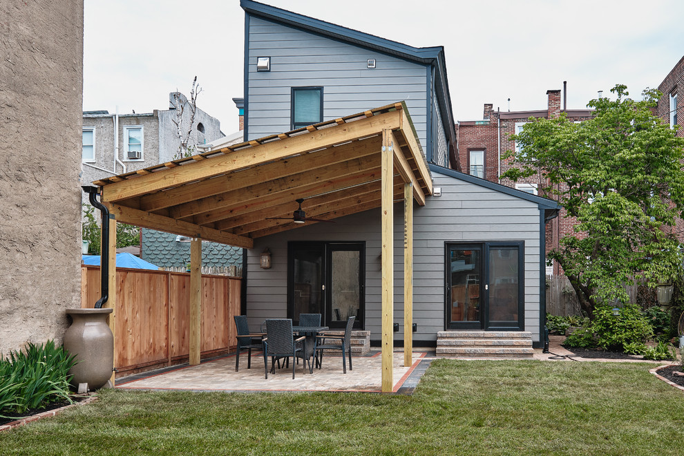 Expansive and gey bohemian two floor concrete detached house in Philadelphia with a lean-to roof and a shingle roof.