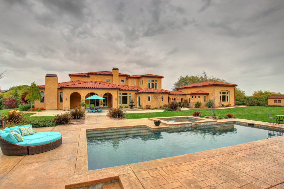 Large mediterranean orange two-story stucco house exterior idea in Sacramento with a hip roof and a tile roof