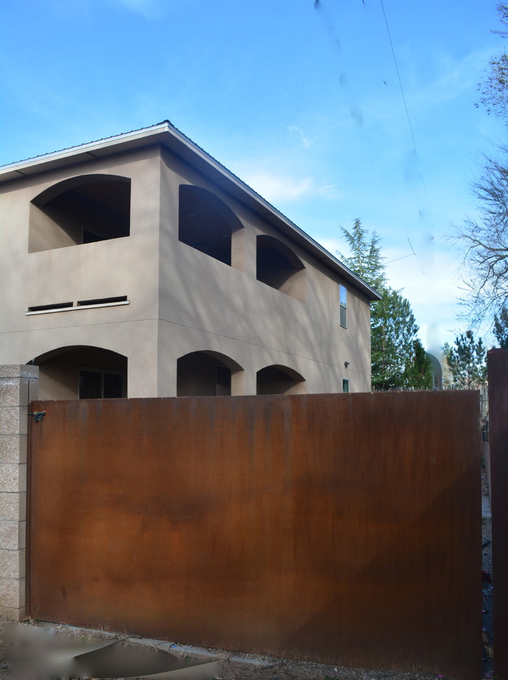 Пример оригинального дизайна: двухэтажный, бежевый дом среднего размера в стиле фьюжн с облицовкой из цементной штукатурки