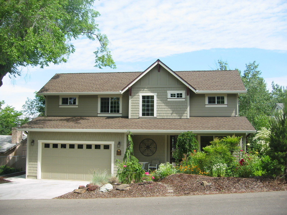 Réalisation d'une façade de maison verte craftsman en béton de taille moyenne et à un étage avec un toit à deux pans.