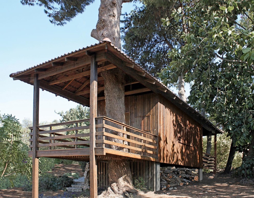 Immagine della villa marrone rustica a un piano con rivestimento in legno, tetto a padiglione e copertura in tegole