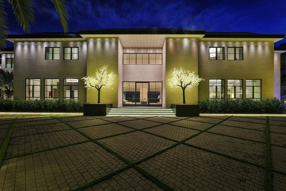 Ejemplo de fachada de casa beige moderna grande de dos plantas con revestimiento de piedra y tejado plano