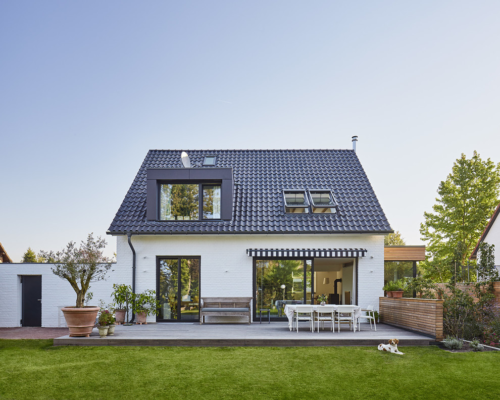 Inspiration for a medium sized and white traditional bungalow brick house exterior in Dusseldorf with a pitched roof.