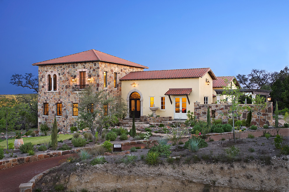 This is an example of a mediterranean two floor house exterior in Austin.