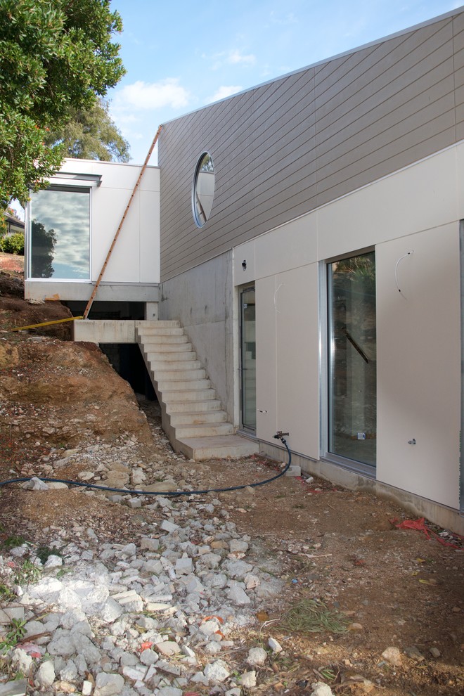 Inspiration for a mid-sized modern beige two-story concrete fiberboard exterior home remodel in Adelaide with a shed roof