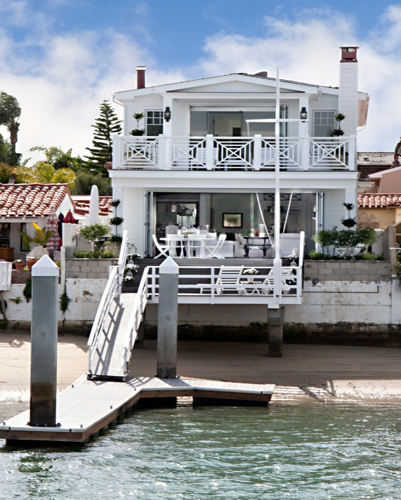 This is an example of a white beach style two floor house exterior in Orange County.