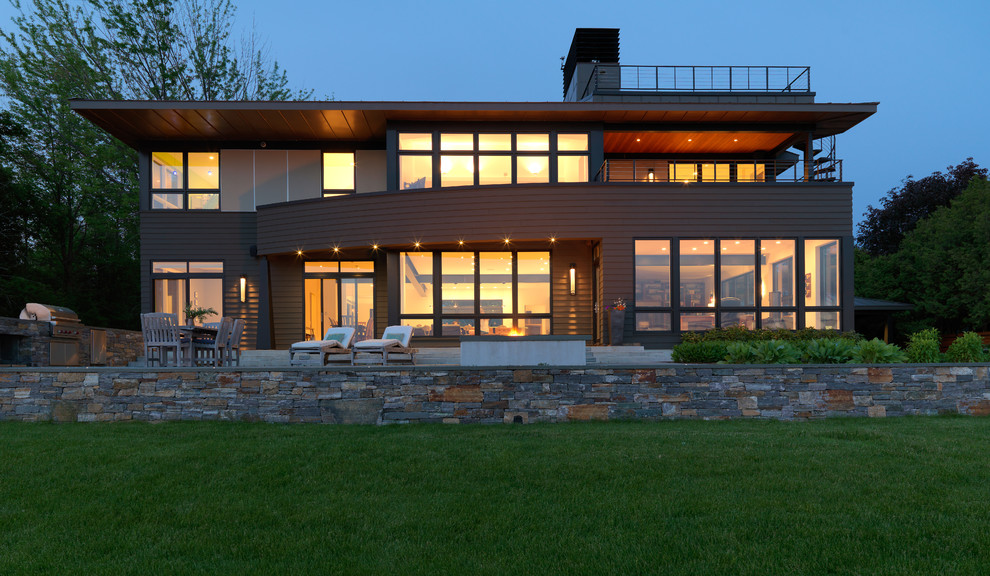 Modelo de fachada marrón minimalista de dos plantas con revestimientos combinados y tejado a cuatro aguas