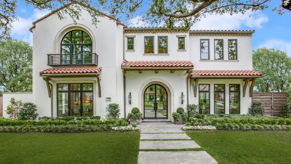 Zweistöckiges Mediterranes Einfamilienhaus mit weißer Fassadenfarbe, Satteldach und Ziegeldach in Dallas
