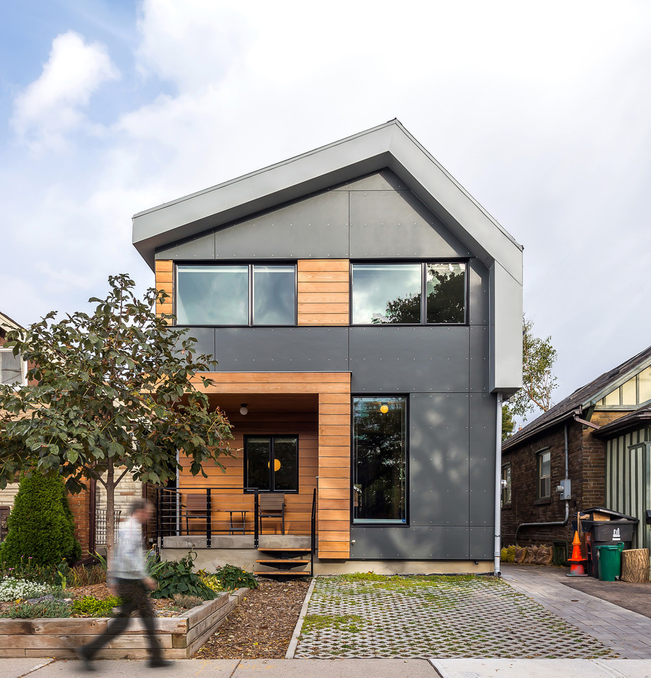 This is an example of a medium sized contemporary two floor house exterior in Toronto with concrete fibreboard cladding and a pitched roof.