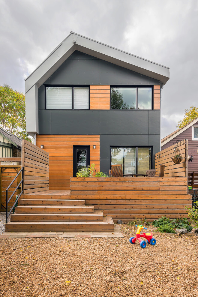 Cette photo montre une façade de maison grise tendance à un étage avec un revêtement mixte et un toit à deux pans.