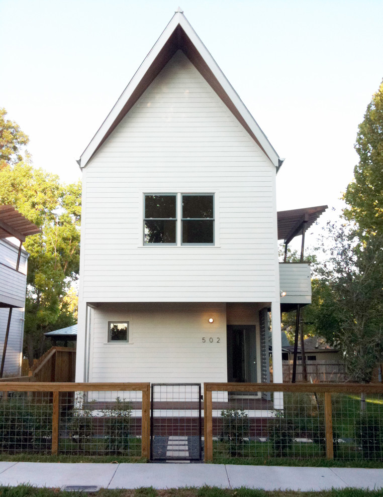 Immagine della facciata di una casa bianca contemporanea a due piani con rivestimento in legno