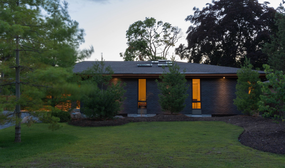 Idées déco pour une façade de maison noire contemporaine en brique de taille moyenne et de plain-pied avec un toit à quatre pans.