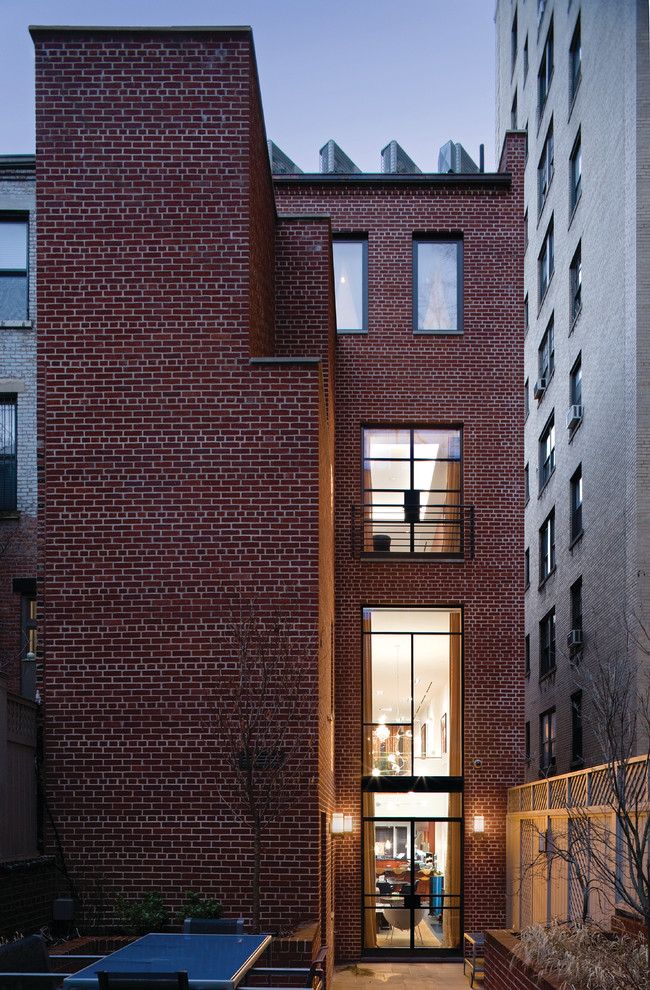 Imagen de fachada contemporánea de tres plantas con revestimiento de ladrillo