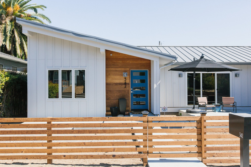 На фото: деревянный, белый частный загородный дом среднего размера в современном стиле с двускатной крышей, металлической крышей и отделкой доской с нащельником