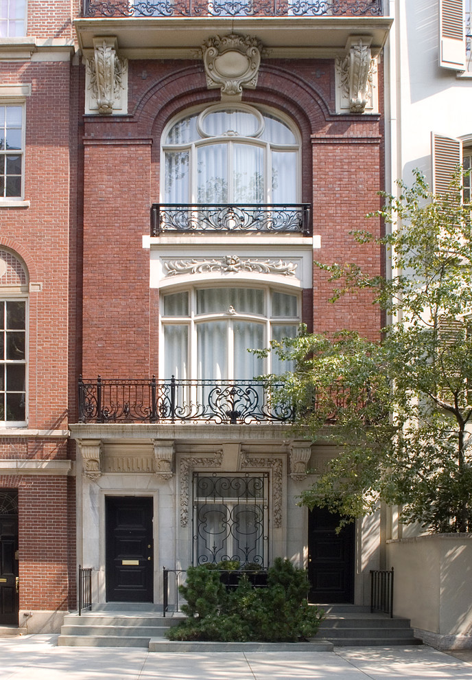 Diseño de fachada clásica de tres plantas con revestimiento de ladrillo