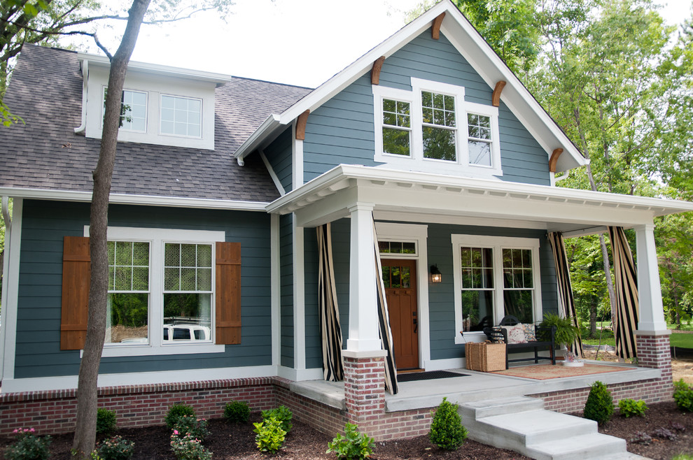 Cette photo montre une façade de maison multicolore chic en bois de taille moyenne et à un étage avec un toit à croupette.