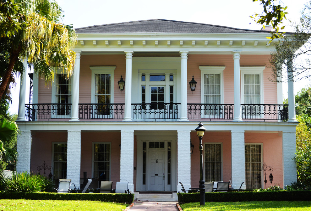 Zweistöckiges Klassisches Einfamilienhaus mit Mix-Fassade, Walmdach, Schindeldach und pinker Fassadenfarbe in New Orleans
