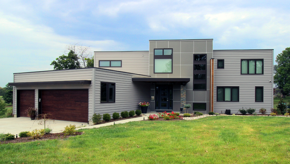Imagen de fachada gris actual grande de dos plantas con revestimiento de aglomerado de cemento