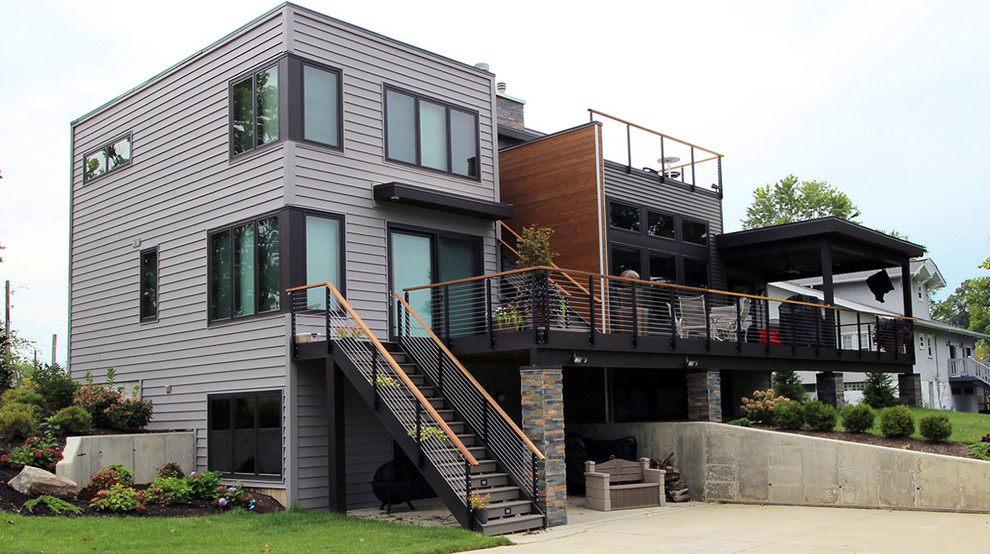 Foto på ett stort funkis grått hus, med två våningar och vinylfasad