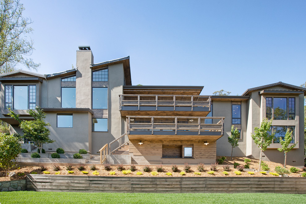 Cette photo montre une façade de maison grise tendance à un étage avec un toit en appentis.