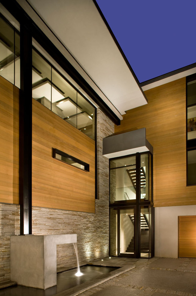 Ejemplo de fachada beige moderna de tamaño medio de dos plantas con revestimientos combinados