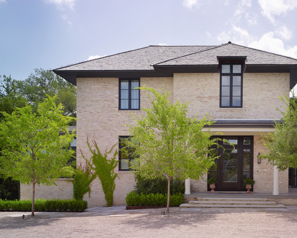 Beige brick house exterior photo in Austin with a hip roof and a shingle roof