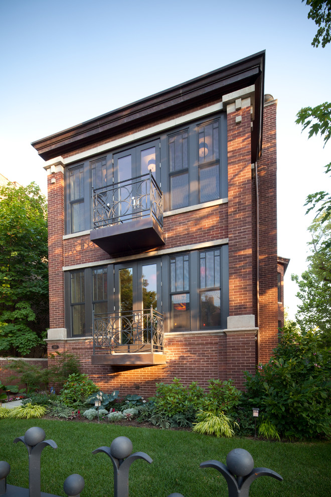 Large elegant red three-story brick exterior home photo in Chicago with a mixed material roof