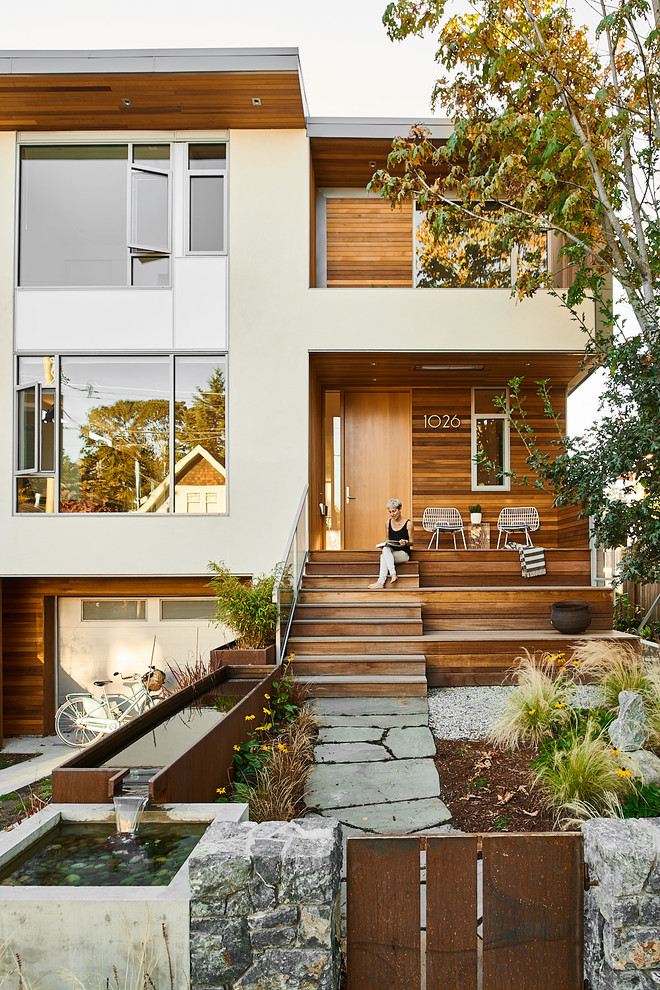 Exemple d'une façade de maison multicolore tendance de taille moyenne et à un étage avec un revêtement mixte et un toit à croupette.