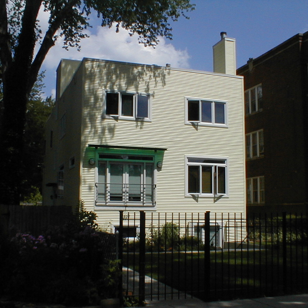 Пример оригинального дизайна: большой, трехэтажный, желтый дом в стиле модернизм с плоской крышей