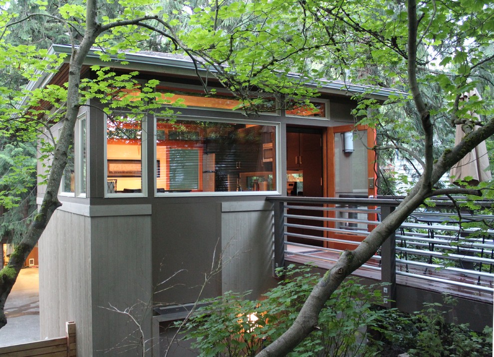 Idee per la facciata di una casa piccola grigia moderna a due piani con rivestimento in legno