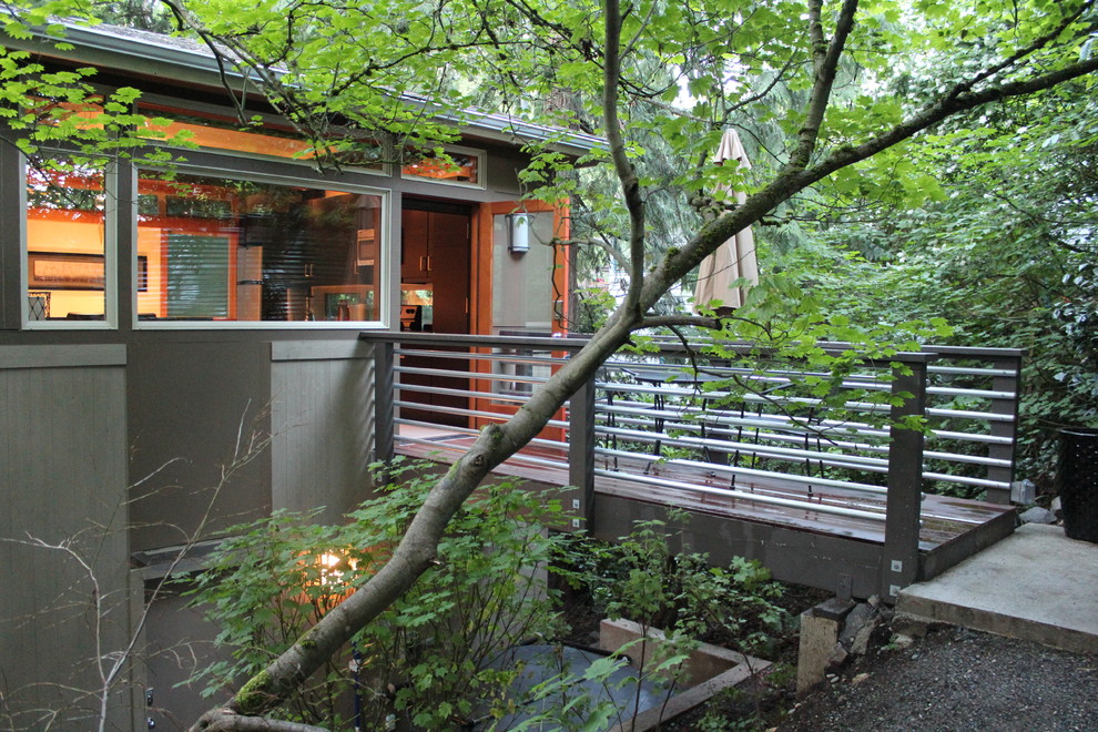 Cette image montre une petite façade de maison grise minimaliste en bois à un étage.