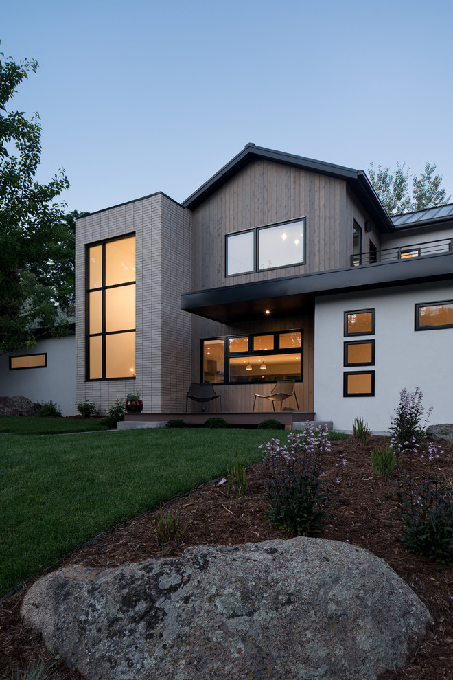 Modelo de fachada de casa blanca contemporánea de tamaño medio de dos plantas con revestimientos combinados, tejado a dos aguas y tejado de metal