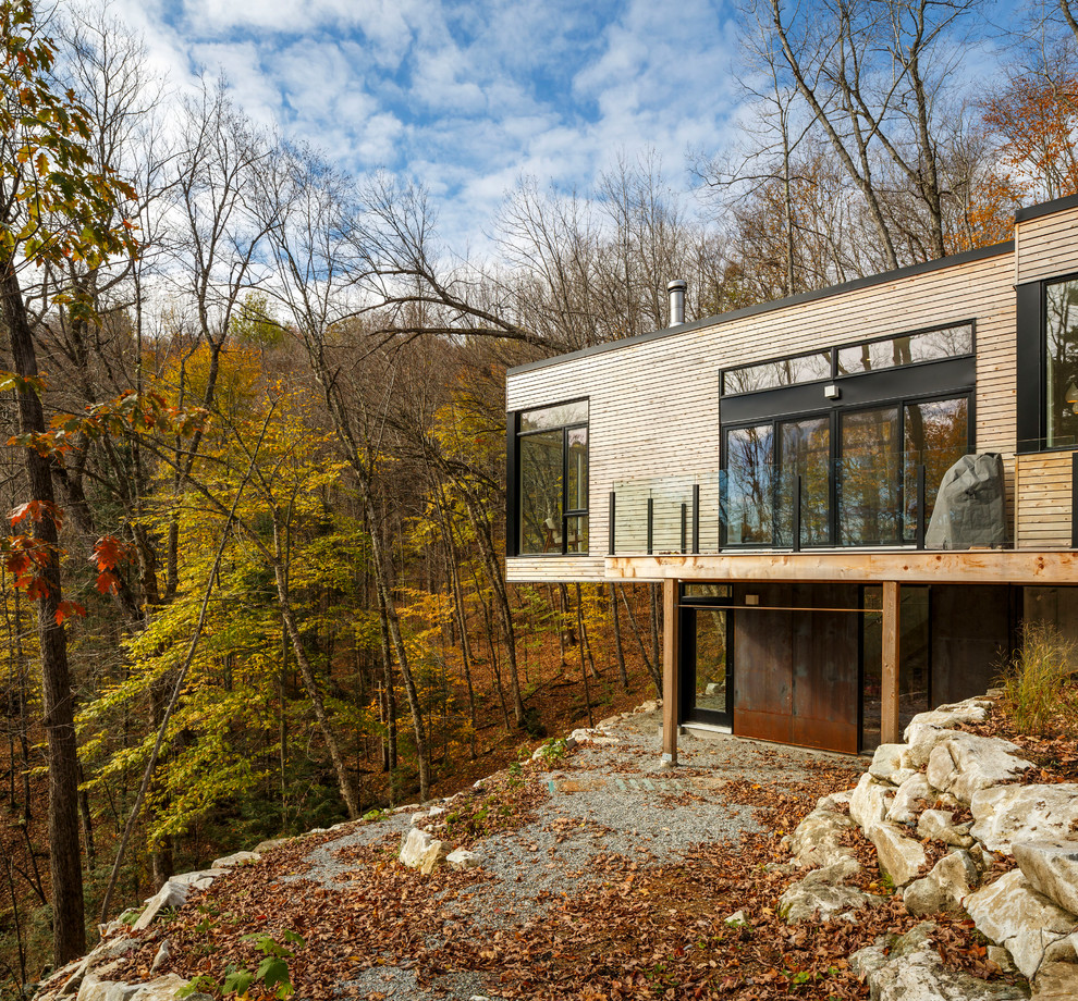 Idées déco pour une façade de maison montagne en bois à un étage avec un toit plat.