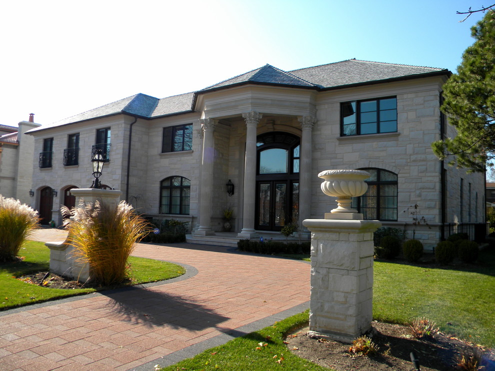 This is an example of a gey traditional house exterior in Chicago with stone cladding.