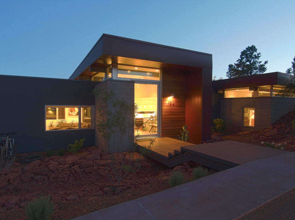 На фото: двухэтажный, коричневый частный загородный дом среднего размера в стиле модернизм с облицовкой из металла и плоской крышей с
