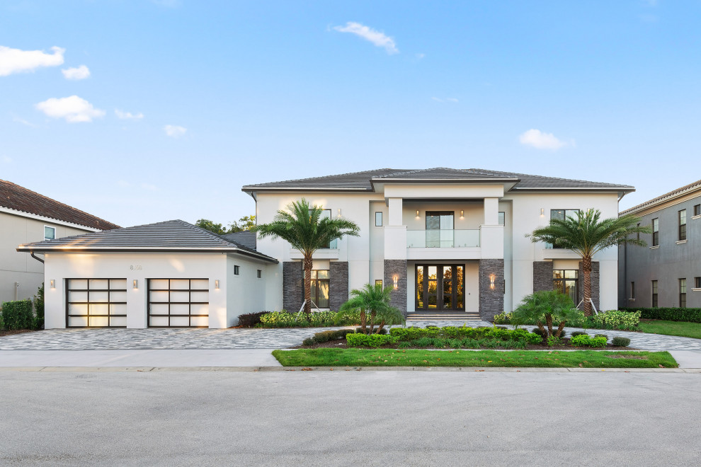 Large trendy multicolored two-story mixed siding house exterior photo in Orlando with a hip roof