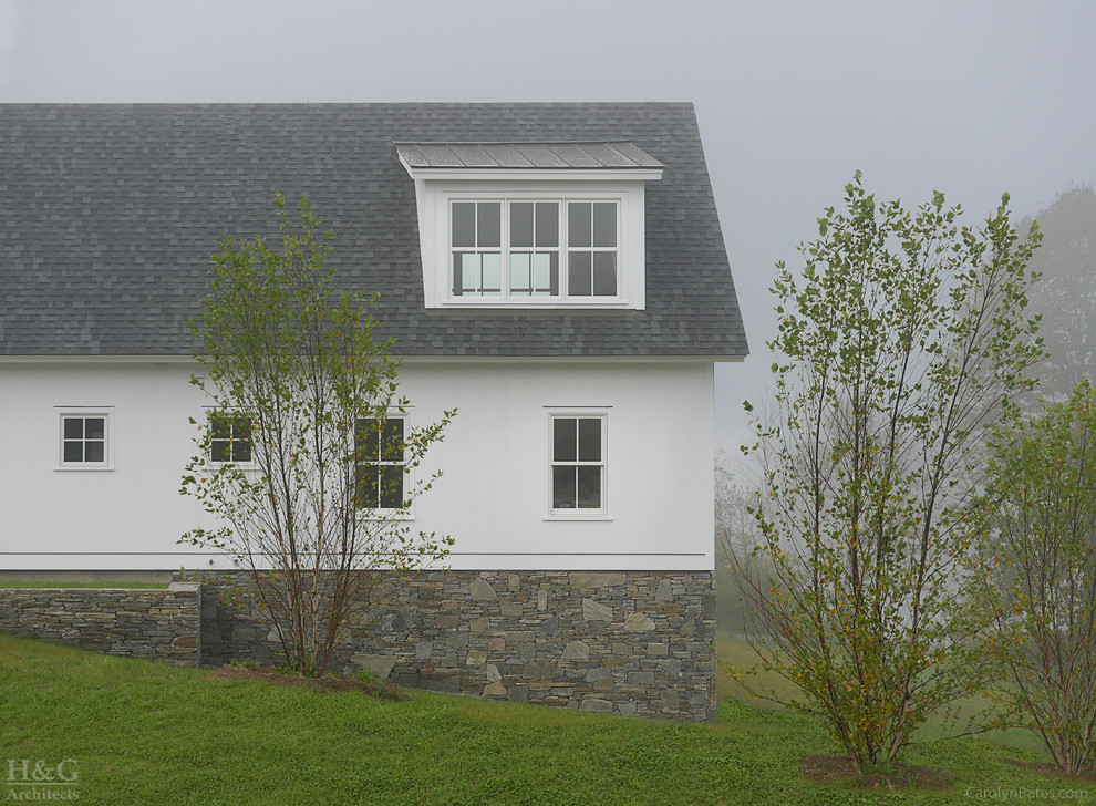Foto de fachada blanca campestre de dos plantas con revestimiento de madera y tejado a dos aguas