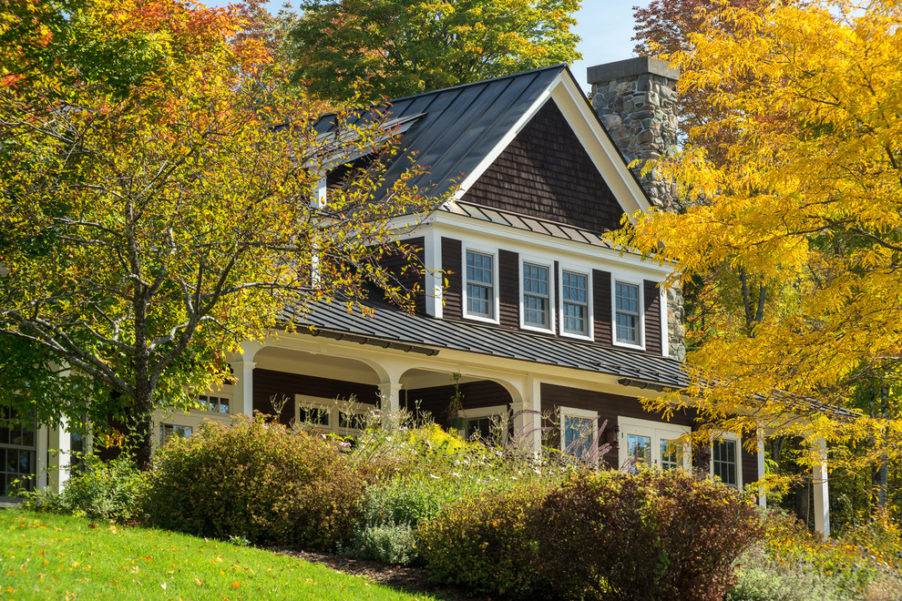 Modelo de fachada marrón de estilo de casa de campo grande de dos plantas con revestimiento de madera y tejado a dos aguas