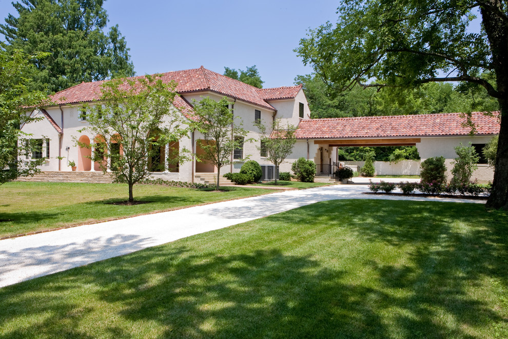 Example of a large tuscan beige two-story stucco exterior home design in Nashville with a hip roof