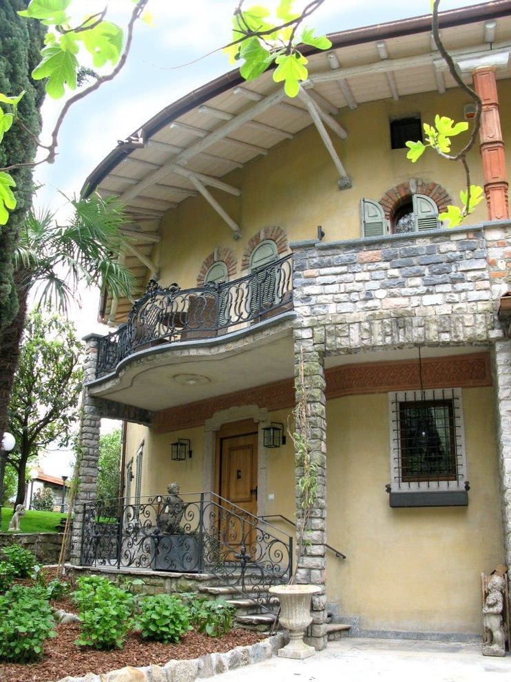 Inspiration pour une très grande façade de maison beige traditionnelle en stuc à un étage avec un toit à deux pans.