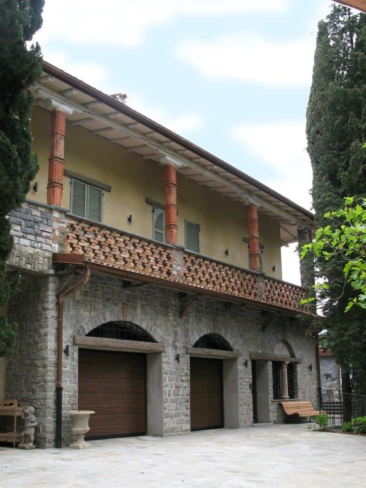 Inspiration pour une très grande façade de maison beige traditionnelle en stuc à un étage avec un toit à deux pans.