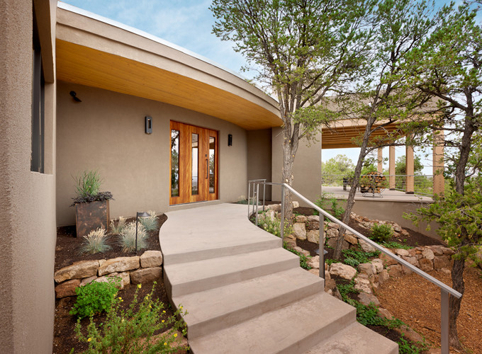 Photo of a large and gey bungalow render house exterior in Albuquerque with a flat roof.