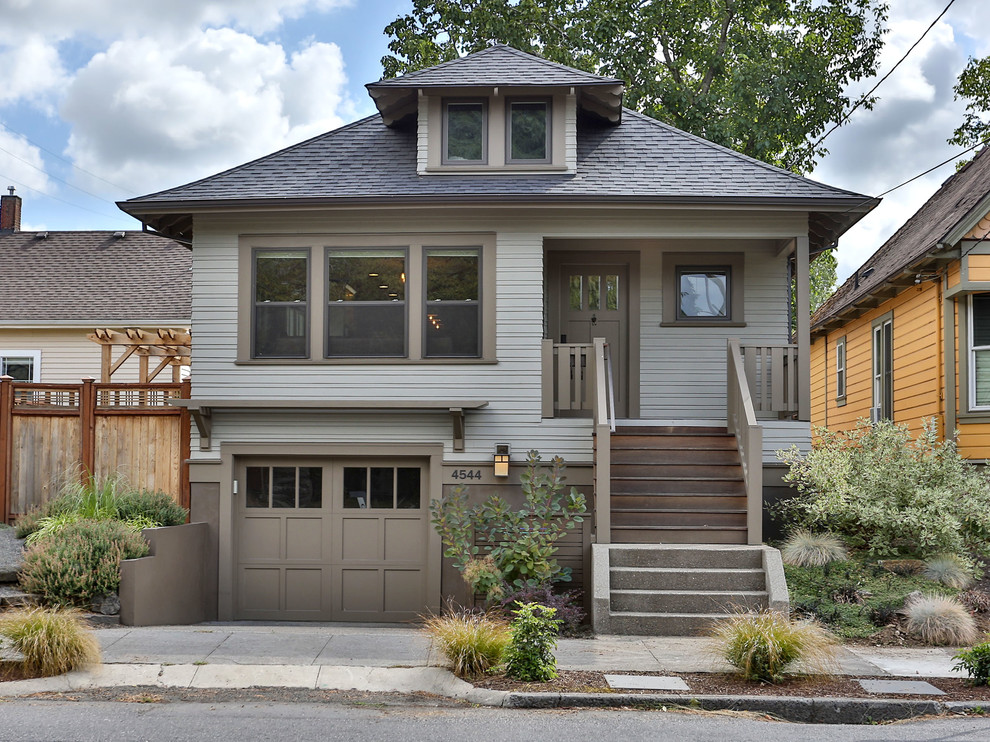 Imagen de fachada de casa gris de estilo americano de dos plantas con tejado a cuatro aguas y tejado de teja de madera