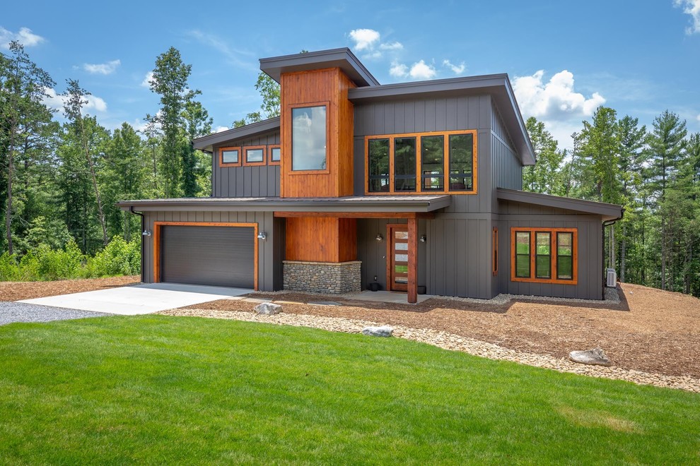 Источник вдохновения для домашнего уюта: двухэтажный, коричневый частный загородный дом среднего размера в стиле лофт с облицовкой из ЦСП, односкатной крышей и металлической крышей