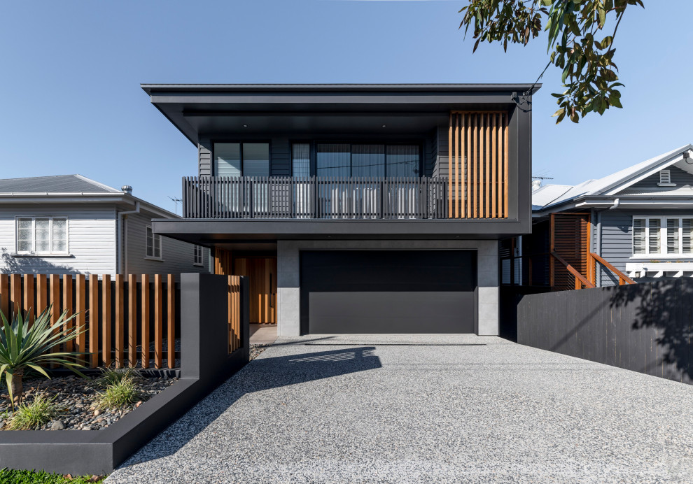 Cette photo montre une façade de maison noire tendance à un étage avec un revêtement mixte et un toit plat.