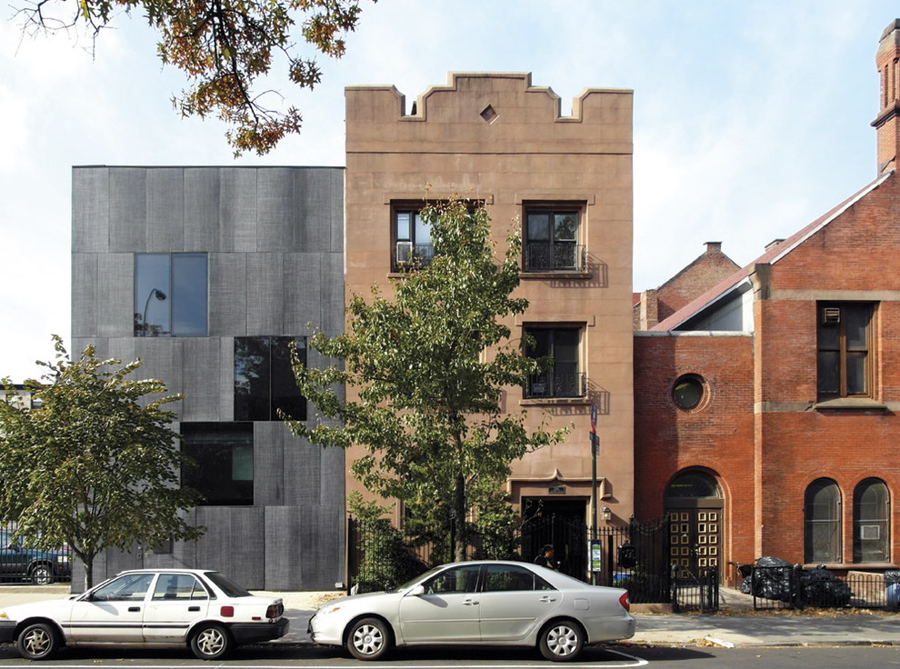 Immagine della facciata di una casa grande industriale a tre piani con rivestimento in pietra